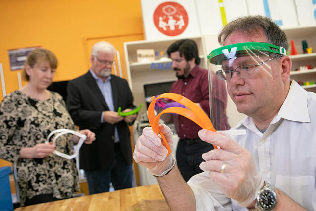 iCreate Director David Ecker holds a face shield produced at the makerspace