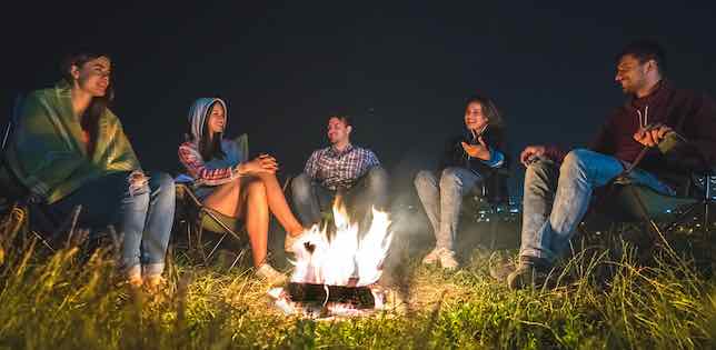 people sitting around campfire