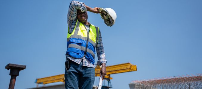 Construction worker standing outside in summer heat