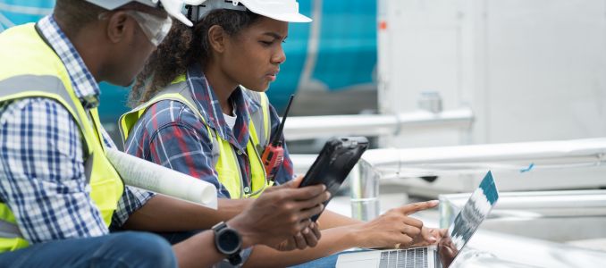 Two workers using laptop and tablet