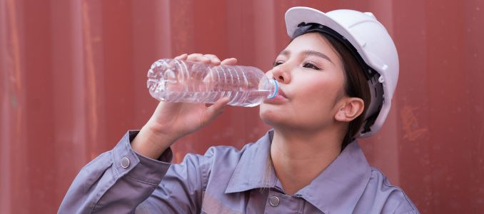 Female container worker drinking water in break time