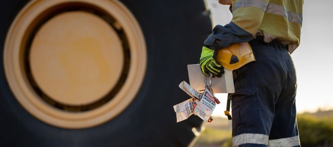 Worker wearing PPE holds LOTO notices