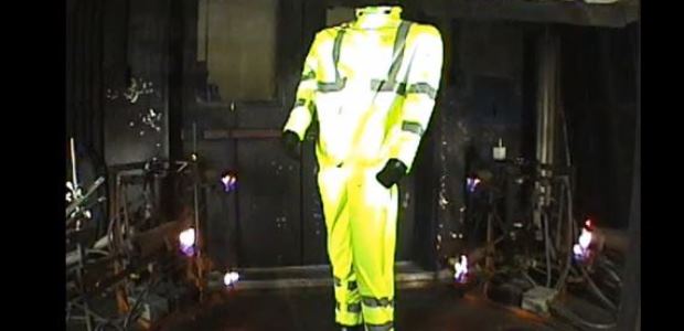 This image is a screen capture from a 2013 Bulwark video showing an arc and flash fire rated rain suit being exposed to a three-second flash fire. The test method depicted in the video is ASTM F 1930, which is the flame exposure test used in NFPA 2112 and ASTM F 2733.