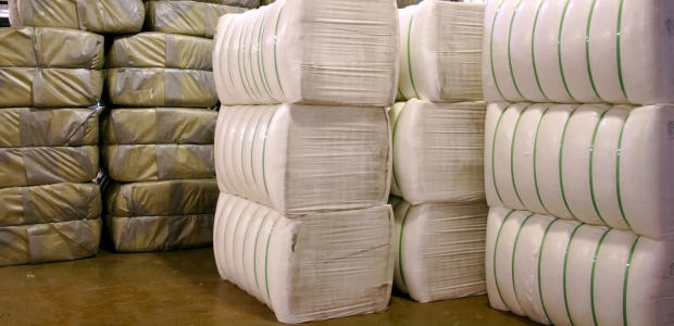 Huge bales of fiber—from 400 to 700 pounds each, depending on the fiber—are delivered to a yarn plant for processing. (TenCate Protective Fabrics photo)