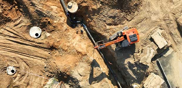 an aerial view of an excavator overtop of a trench