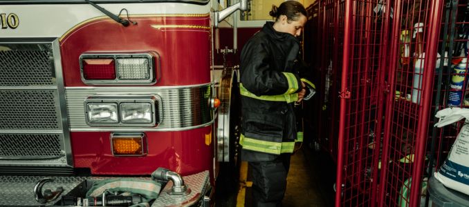 Firefighter putting on uniform