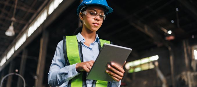 Engineer worker safety helmet tablet factory woman vest inspection focused female engineer using tablet in industrial factory