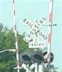 a railroad grade crossing sign, lights, and warning gates