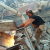 Image of a 9/11 recovery worker cutting through rubble.