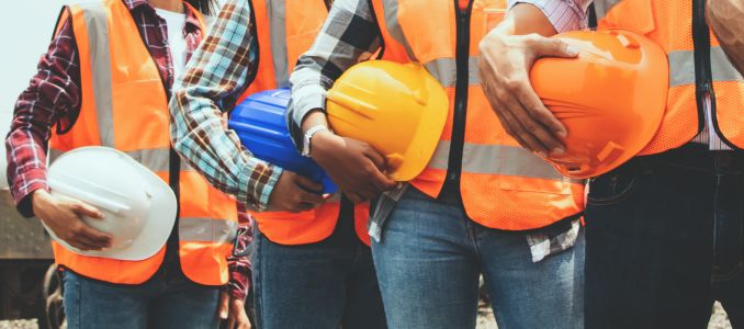 Workers holding safety helmets