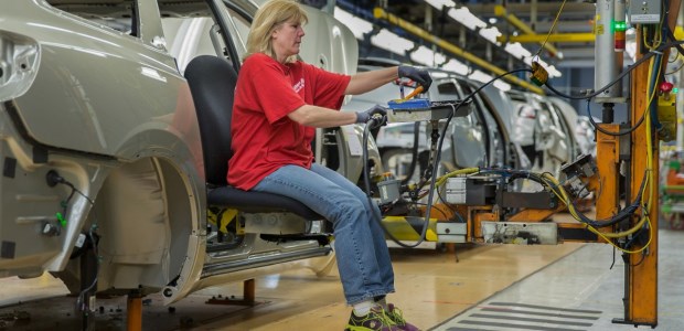 Autoworkers at the Lansing plant use the Ergo Chair to finish work in the rear of the Chevrolet Traverse with tools and parts alongside, at the right height for their work, according to GM.