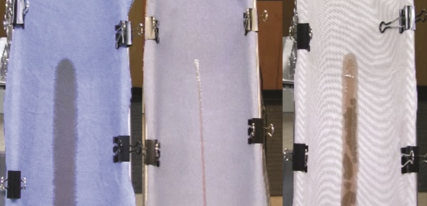 Photo 1. ISO 6530 test equipment with multiple layers of fabric clamped to "gutter." (Lakeland Industries photo)