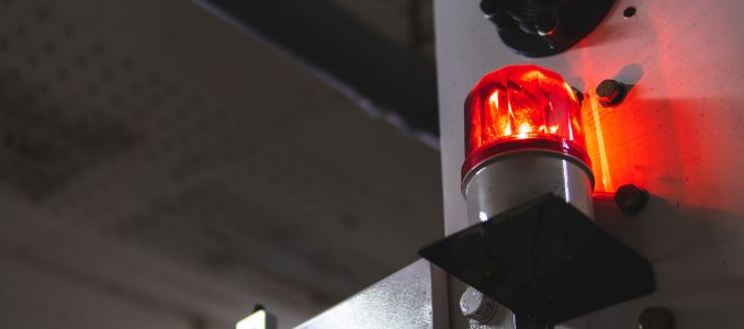 blurred low key Illuminated factory industry red alert emergency light with copy space for background