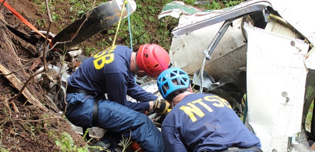 This June, 30, 2015, photo shows NTSB Investigators Brice Banning and Clint Crookshanks examining wreckage from the aircraft  that had crashed five days earlier near Ketchikan, Alaska. (NTSB photo by Ketchikan Volunteer Rescue Squad – Jerry Kiffer)