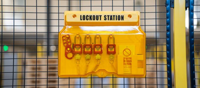 Lockout safety station with safety locks on industrial machine fence