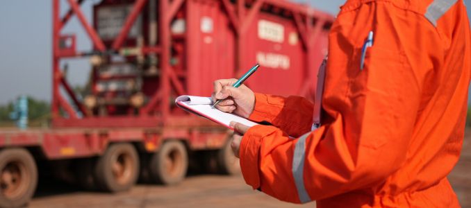 A safety officer is checking on safety checklist form during perform inspection