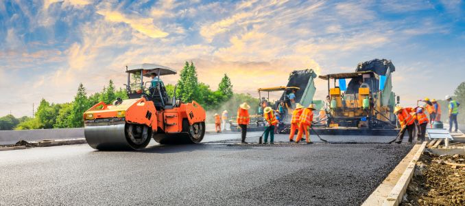 Construction site is laying new asphalt road pavement,road construction workers and road construction machinery scene