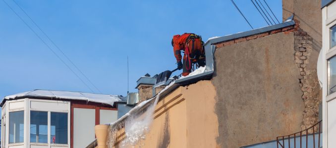 Worker on Snowy Roof