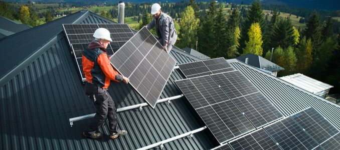 Workers Installing Solar Panels on Roof