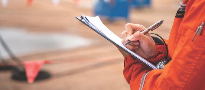 Person Writing on a Clipboard