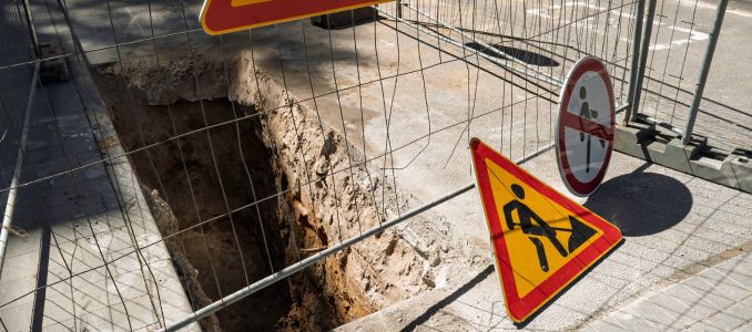 Safety signs around deep trench in road