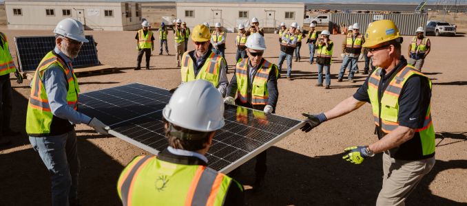 Construction workers lifting solar panel 