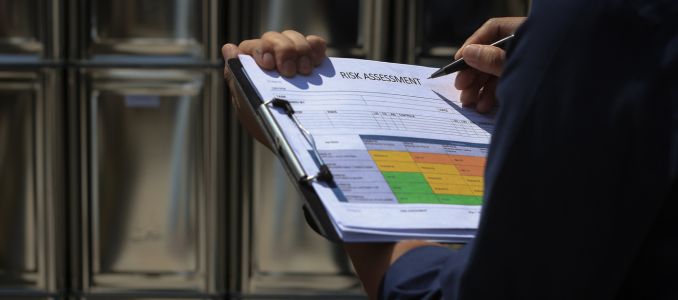 Person holding risk assessment form on clipboard