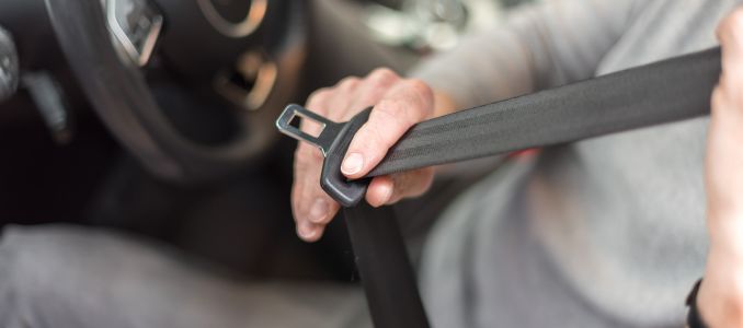 Person putting on seatbelt in car