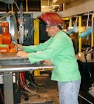 Welding technician Tim Moore prepares a GMAW torch on a mechanized fixture.