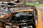 This FEMA photo taken Aug. 28, 2012, by Patricia Brach in Mannford, Okla., shows the aftermath of the Creek County wildfire there. Heat from the fire melted the glass in this car parked in the driveway of a burned-out home. (FEMA/Patricia Brach)