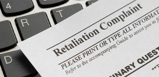 a paper form of a retaliation complaint rests on a keyboard