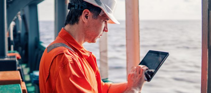 Safety professional holding tablet on boat