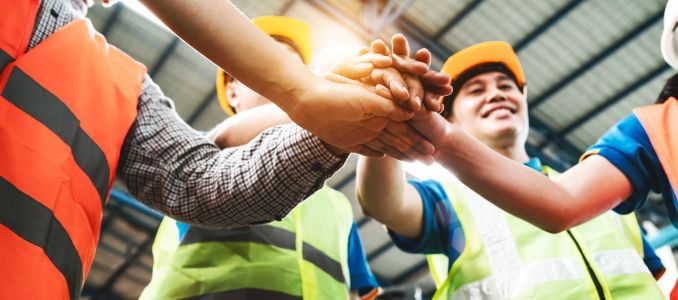 Safety workers doing a hands-in huddle