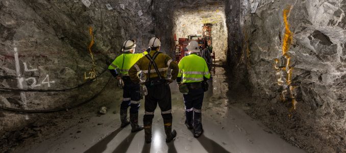 Mine workers examining underground tunnel