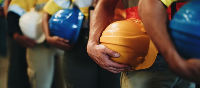 Workers holding hard hats