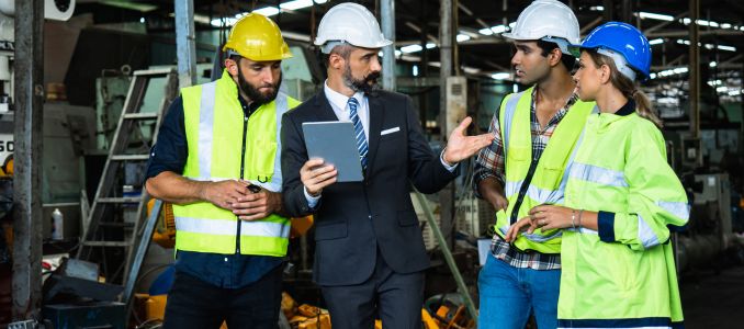 Industrial engineer in factory, planning, discussing and training workers