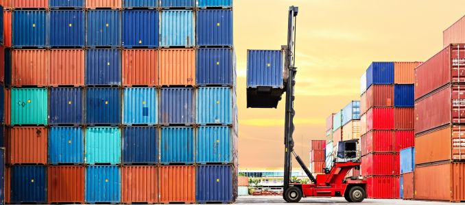 Crane lifting up container in yard