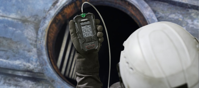 Courtesy of MSA Safety: Worker wearing a hard hat holds an MSA ALTAIR io 6 gas detector near a confined space opening.
