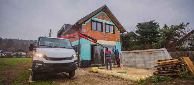 Two workers installing pane of glass