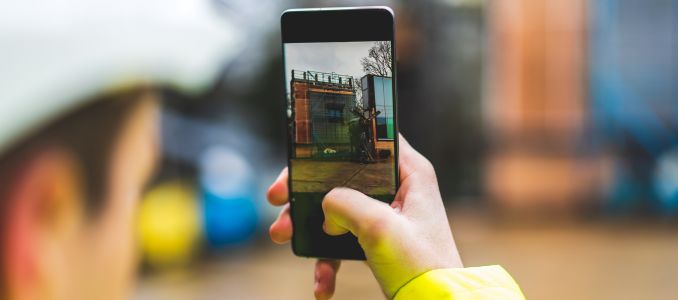 Construction worker taking photo of site