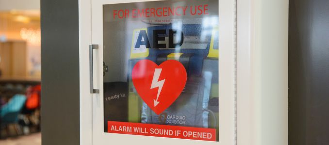AED on wall in glass case