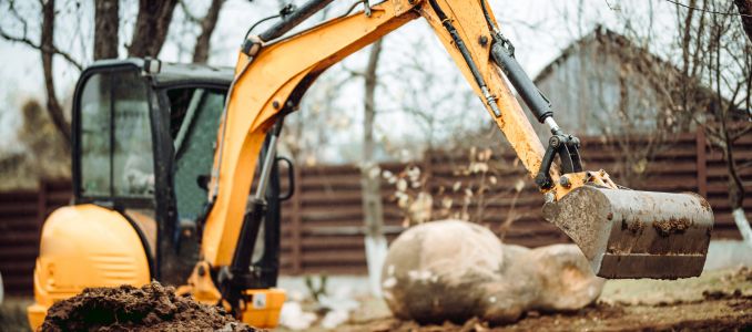 Landscaping works with mini excavator at home construction site